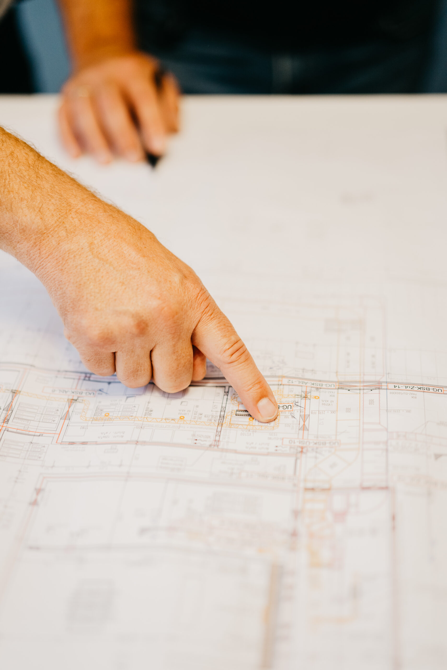 Hand zeigt auf einen technischen Plan bei der Anlagenplanung